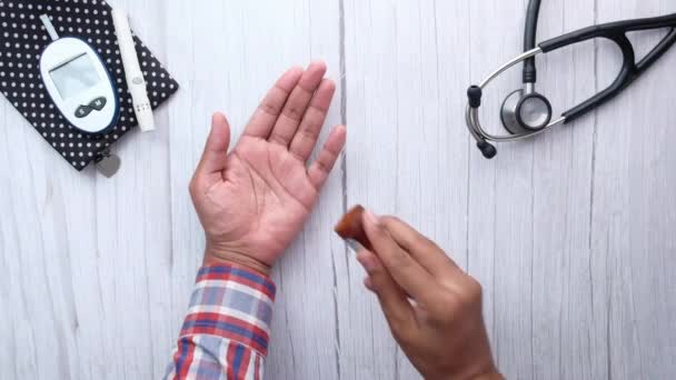 약을 먹는 사람의 손을 보는 맨 위의 모습 — 비디오