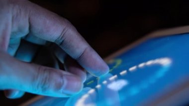 Adam el ile ofis masasında dijital tablet üzerinde çalışıyor, kendi yarattığı grafiği kullanarak. 