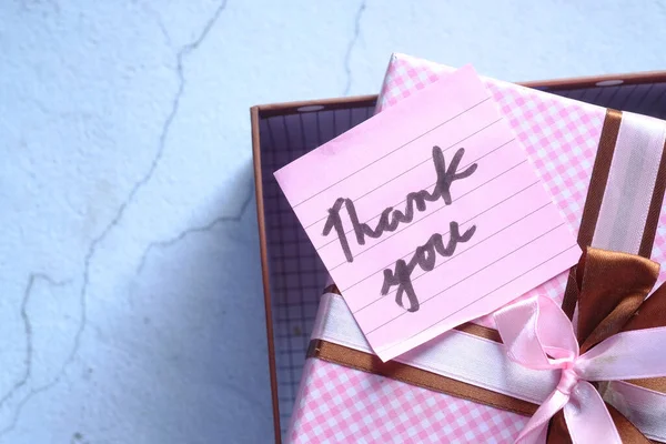 Thank you message on gift box on table — стоковое фото