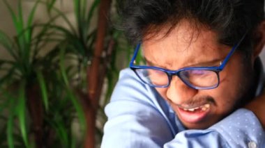 Genç hasta adam burnunu ve ağzını koluyla kapatıyor..