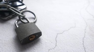 Beyaz Arkaplanda Zincir ve Asma Kilitli Akıllı Telefon.