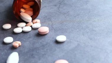 Siyah arka plana dökülen beyaz hapları kapat 