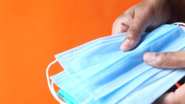  Adam elinde cerrahi maske tutuyor, yakın plan. 