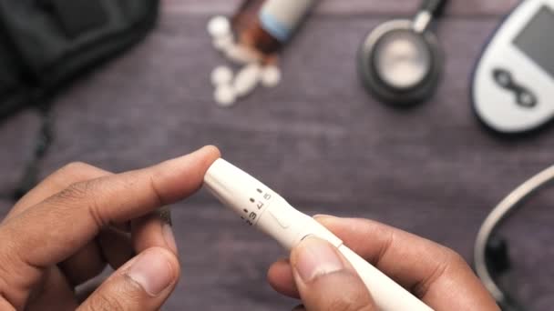 テーブルの上で糖尿病を測定する人の手の上のビュー — ストック動画
