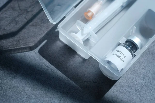 Fechar a vacina contra o coronavírus e a seringa sobre fundo preto — Fotografia de Stock