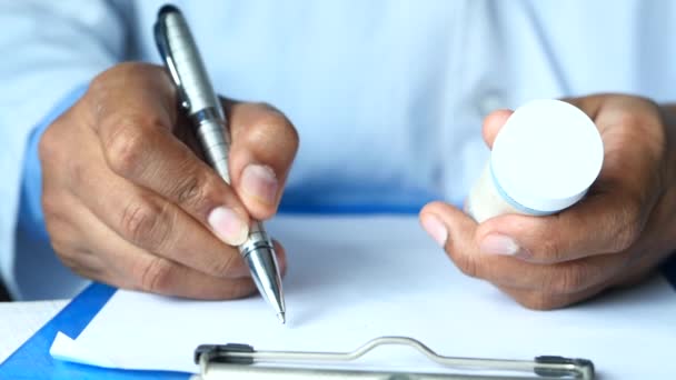 Médico receta de escritura a mano en el escritorio, de cerca. — Vídeo de stock