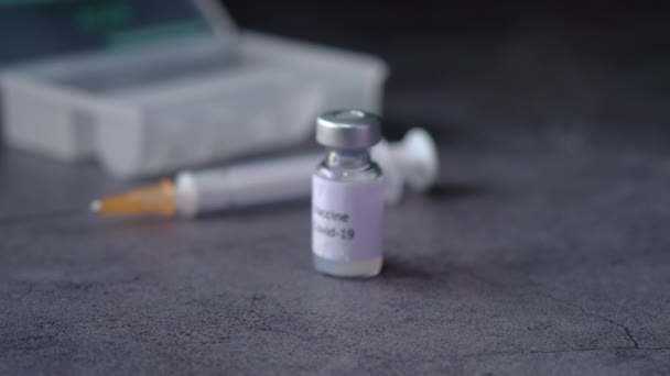 Närbild av coronavirusvaccin och spruta på svart bakgrund — Stockvideo