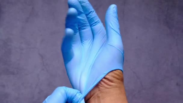 Mężczyzna lekarz nosi medyczne rękawiczki, zbliżenie — Wideo stockowe