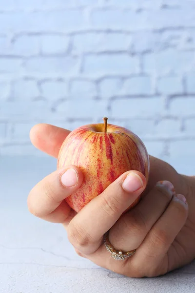 Rött moget äpple på kvinnohand, isolerat på vitt . — Stockfoto