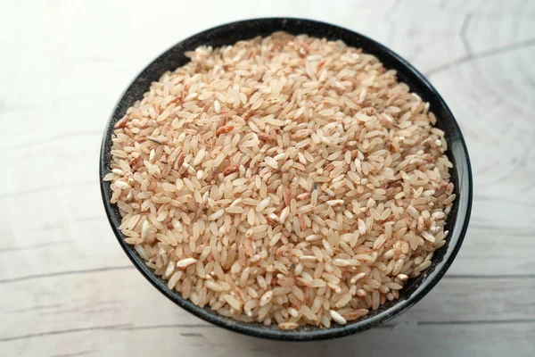 Сырой коричневый рис на деревянном фоне сверху вниз. — стоковое фото