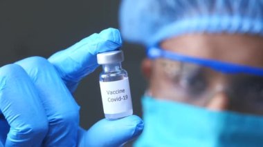 Doktor elinde koronavirüs aşısı olan eldivenleri teslim et.