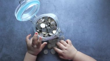 Kavanozda bozuk para saklayan bebek manzarası,
