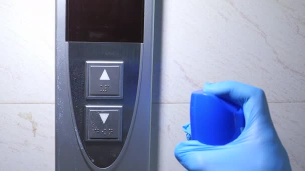 Man hand in protective gloves disinfecting elevator buttons. — Stock Video