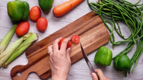 Main de femmes coupant des tomates sur la planche à découper — Video
