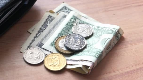 Zbliżenie monet, dolara amerykańskiego i portfela na stole — Wideo stockowe