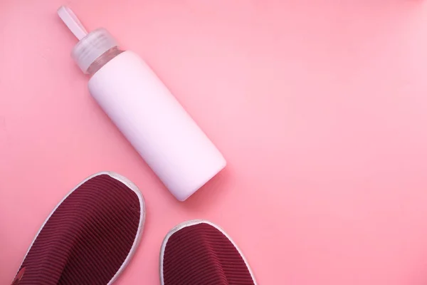 Gesundheits- und Fitnesskonzept mit Schuh und Wasserflasche auf rosa Hintergrund — Stockfoto