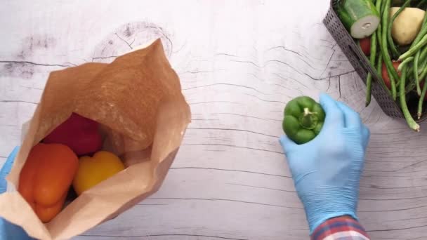 Mão em luvas de proteção tomar capsicum fora do saco de compras — Vídeo de Stock