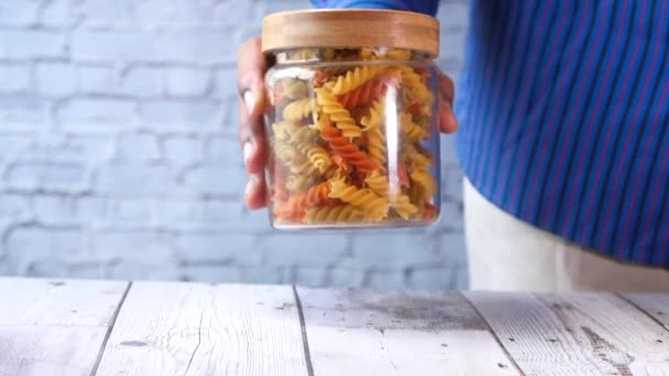 Mann nimmt trockene italienische Pasta aus einem Glas . — Stockvideo