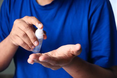 Delikanlının elini dezenfektan spreyiyle kapat..