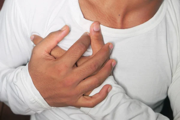 Jonge man lijden hart en houden van zijn borst. — Stockfoto