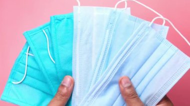  Adamın elinde cerrahi yüz maskesi var. 