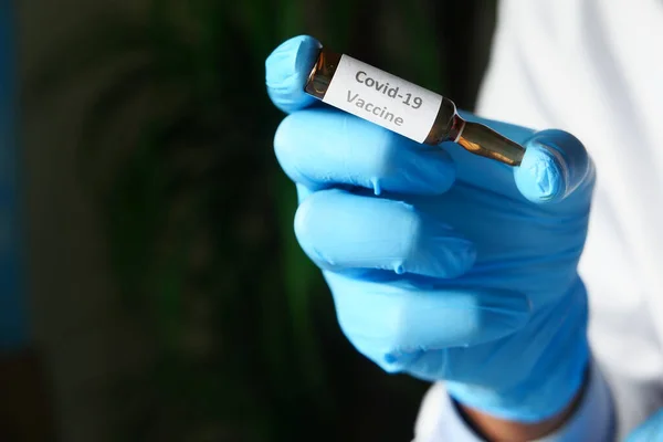 Γιατρός χέρι σε προστατευτικά γάντια που κρατούν το εμβόλιο coronavirus με χώρο αντίγραφο — Φωτογραφία Αρχείου