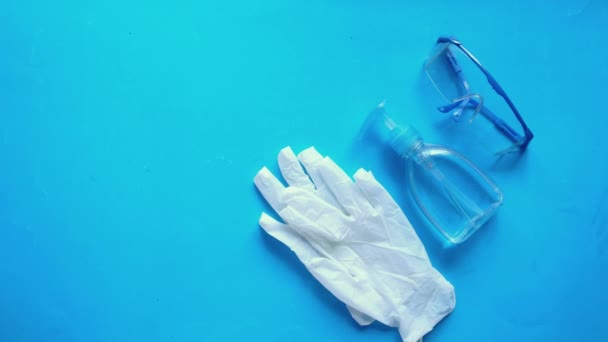 Vista superior de la mano del hombre poniendo máscara facial quirúrgica sobre fondo azul — Vídeos de Stock