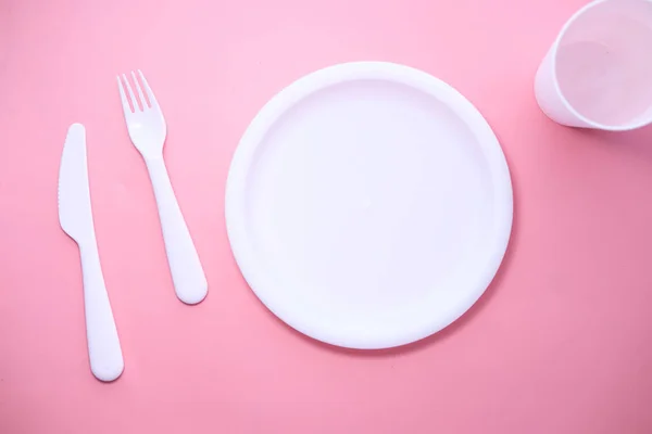 Cutlery and empty plate on pink background top down — Stok Foto