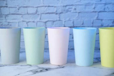 Masanın üzerinde çeşitli renkte plastik cam var..