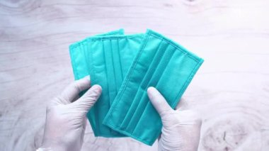  Ellerinde cerrahi maske olan koruyucu eldivenler olan bir adam. 