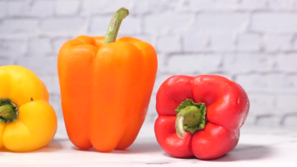 Žlutá oranžová a červená paprika na stole — Stock video