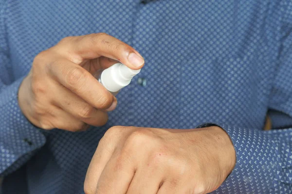 Close up of young man hand using hand sanitizer spray. — Stock Photo, Image