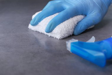 Düz yüzeyi temizleyen mavi lastik eldivenler. 