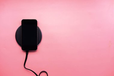 Kablosuz şarj pedi kullanarak akıllı telefon şarj ediliyor, üst görünüm 