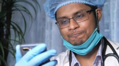 Genç Asyalı doktor kameraya görüntülü konuşma yapıyor..
