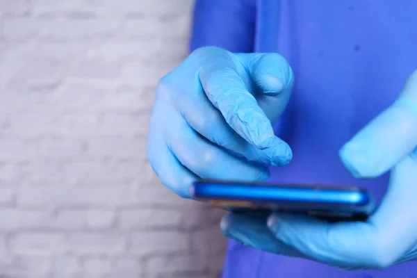 Lékaři rukou v ochranných rukavicích pomocí smartphonu. — Stock fotografie