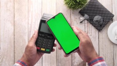 Akıllı bir telefondan ödeme terminali bağlantısı olmayan bir ödemeden ücret alınıyor.