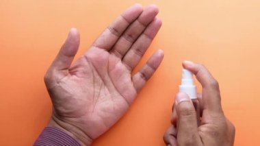 Delikanlının elini dezenfektan spreyiyle kapat..