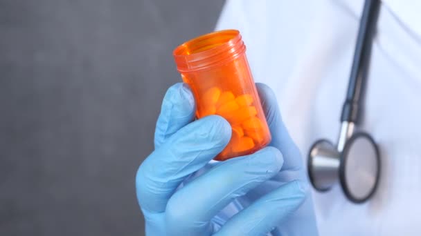 Arzt reicht schützendes Glas mit Tablettenbehälter — Stockvideo