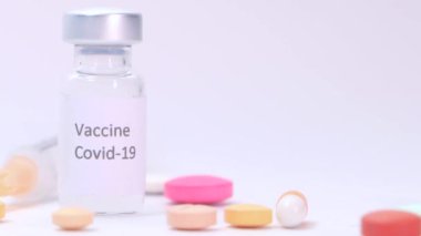 Beyaz zemin üzerinde Coronavirus aşısı ve şırınga kapatın