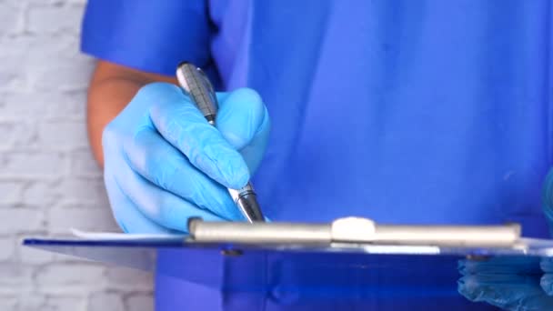 Ręka lekarza w rękawicach ochronnych wypisywanie recepty, — Wideo stockowe