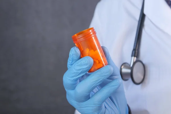 Läkare hand i skyddande glas innehav piller behållare — Stockfoto