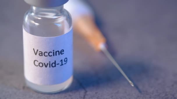 Close-up van het coronavirusvaccin en de spuit op zwarte achtergrond — Stockvideo