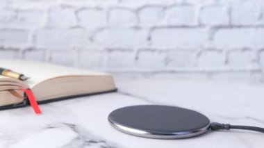 Kablosuz şarj pedi kullanarak akıllı telefonu elle şarj eden kişi, 