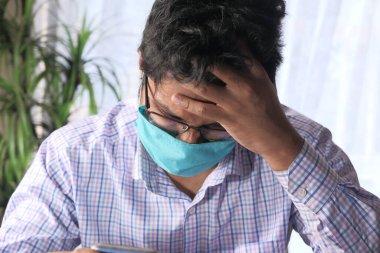 Koruyucu maskeli genç bir Asyalı üzgün hissediyor. 