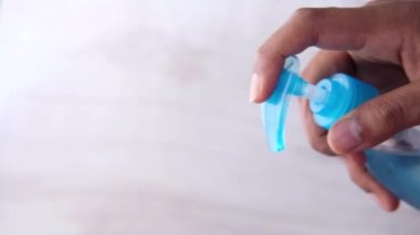 Virüsü önlemek için dezenfektan jel kullanarak genç adamın elini kapat. 