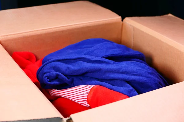 Caixa de doação com roupas de doação em uma mesa de madeira . — Fotografia de Stock