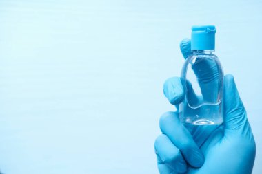 El dezenfektanı tutan koruyucu eldivenler. 