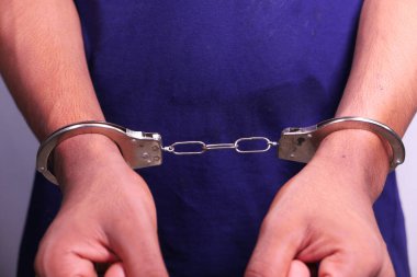 Erkek elleri kelepçeli. Yaklaş.