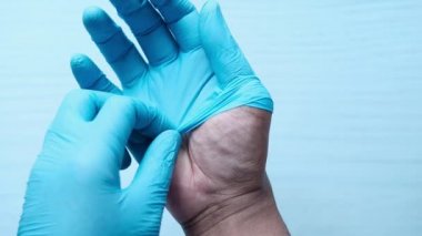 Erkek doktor tıbbi eldiven giyer, yakın plan.